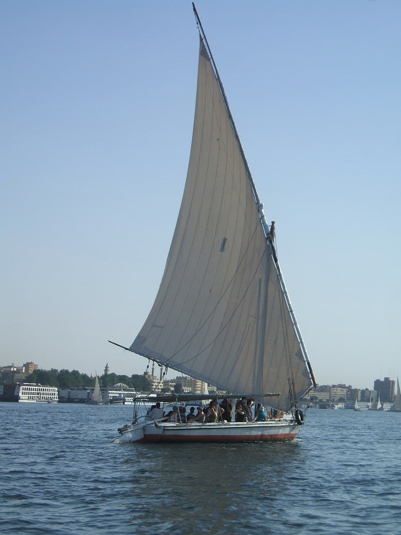 A felucca sailboat with passengers on the Nile near Aswan at sunset