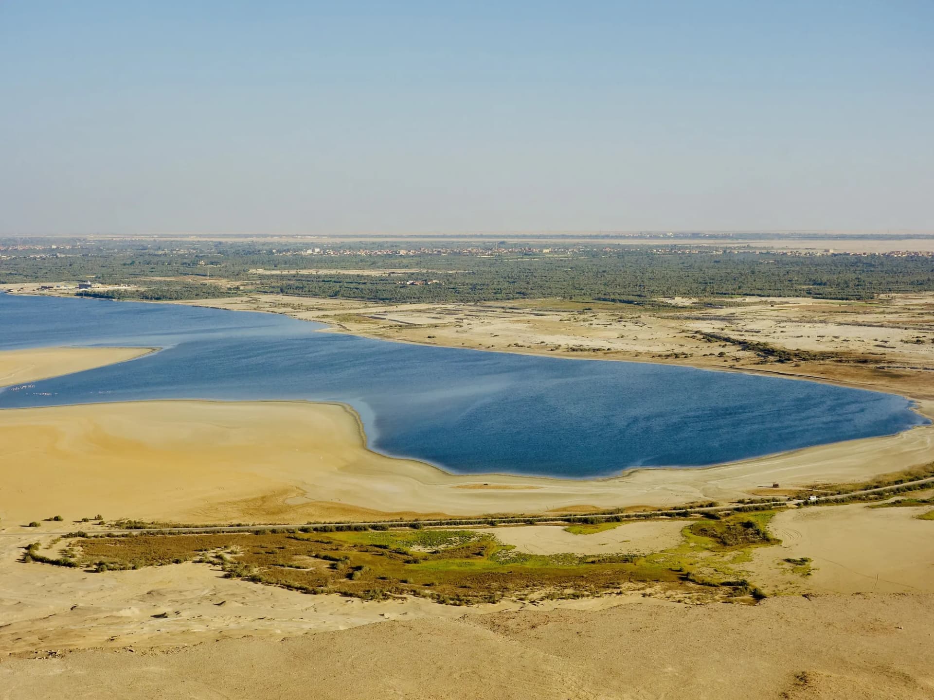 Aerial view of Lake Qarun in Fayoum, with its blue water, sandbanks and green shore