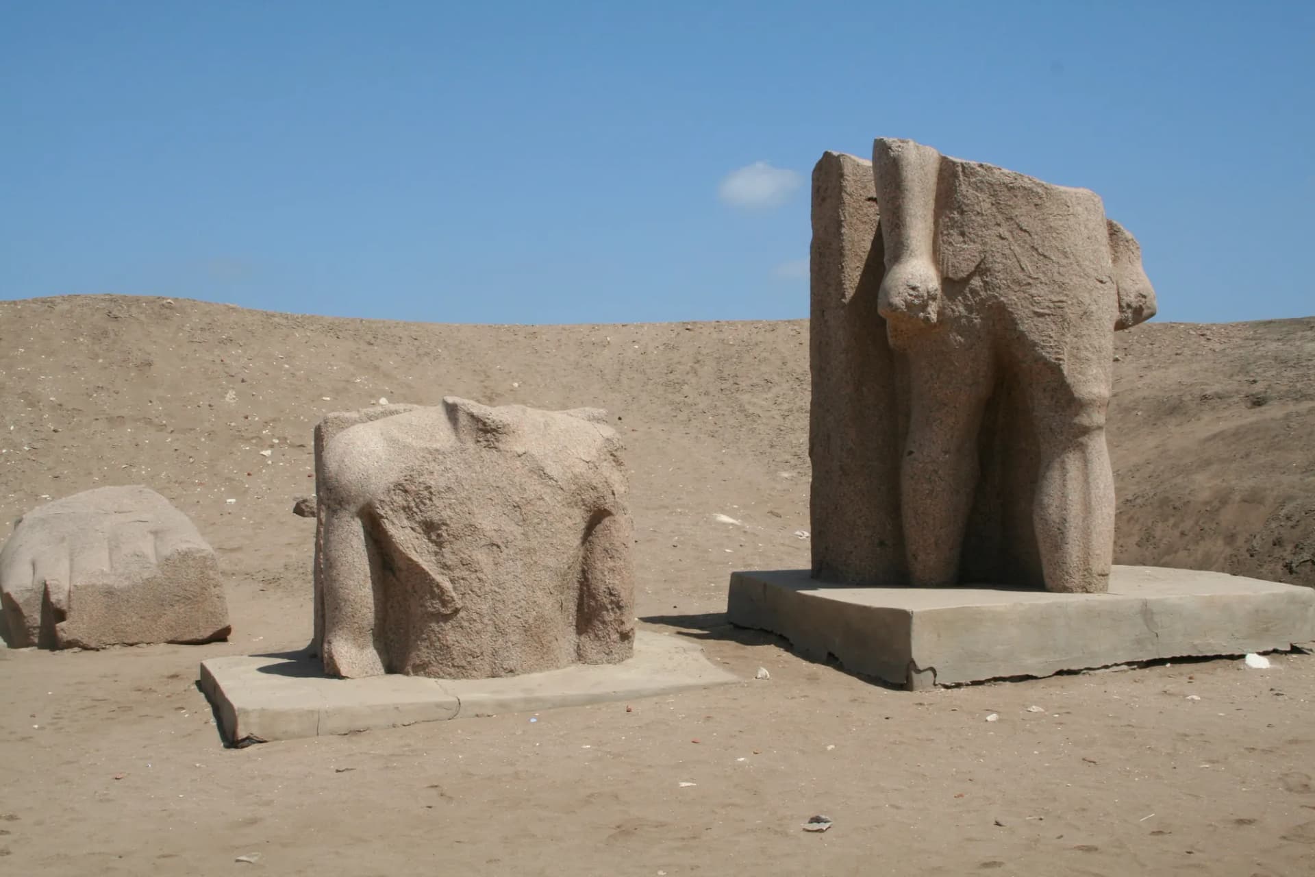 Granite statue fragments standing on low bases among the ruins at Tanis (San El-Hagar)