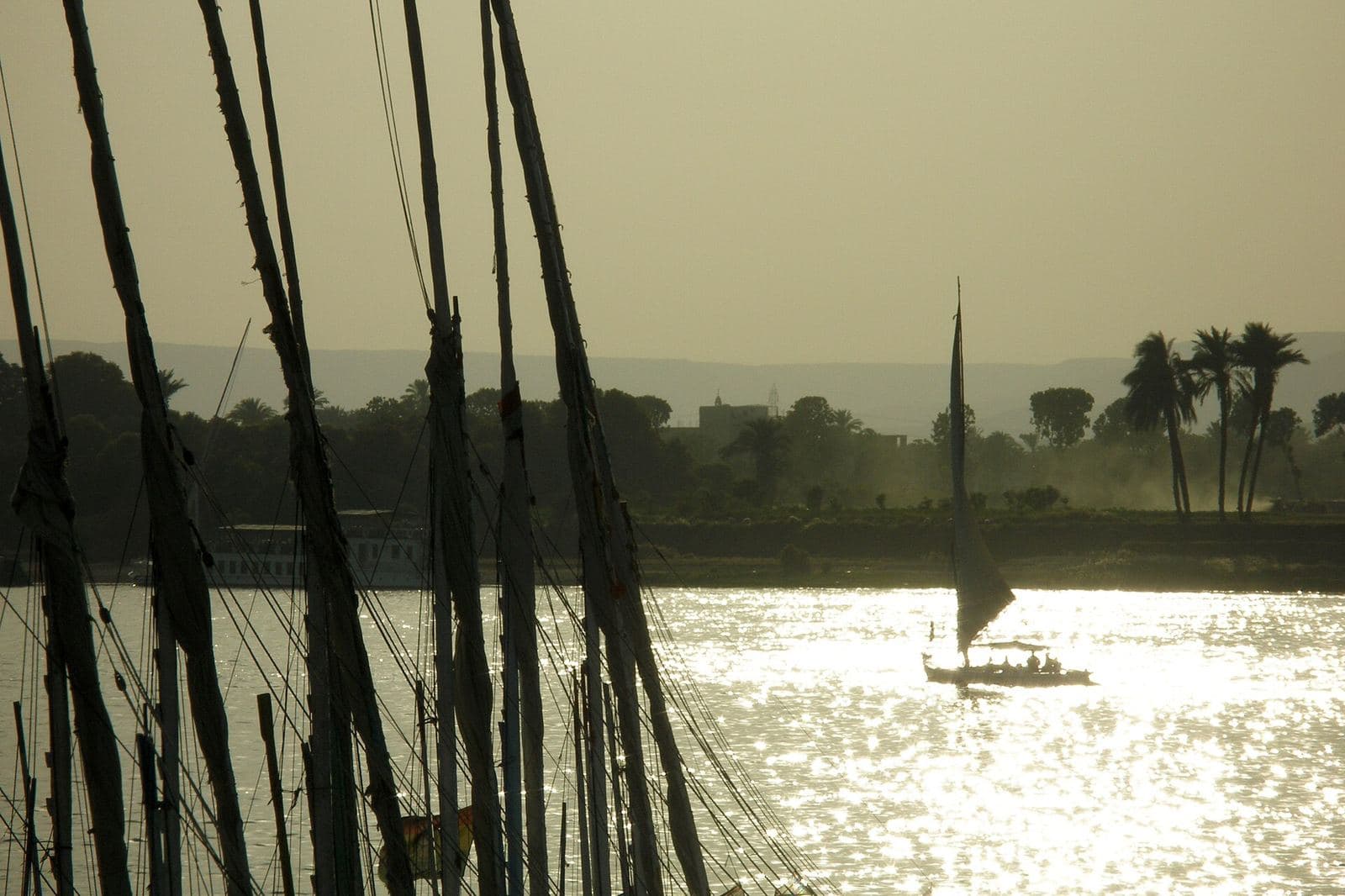 A felucca sailboat silhouetted against the sunset on the Nile at Luxor