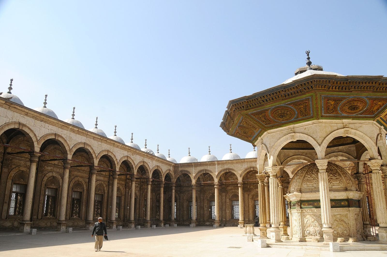 The courtyard of the Mohammed Ali Mosque in Cairo, with a visitor in modest dress
